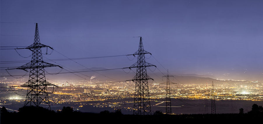 Electrical towers at dawn above a city