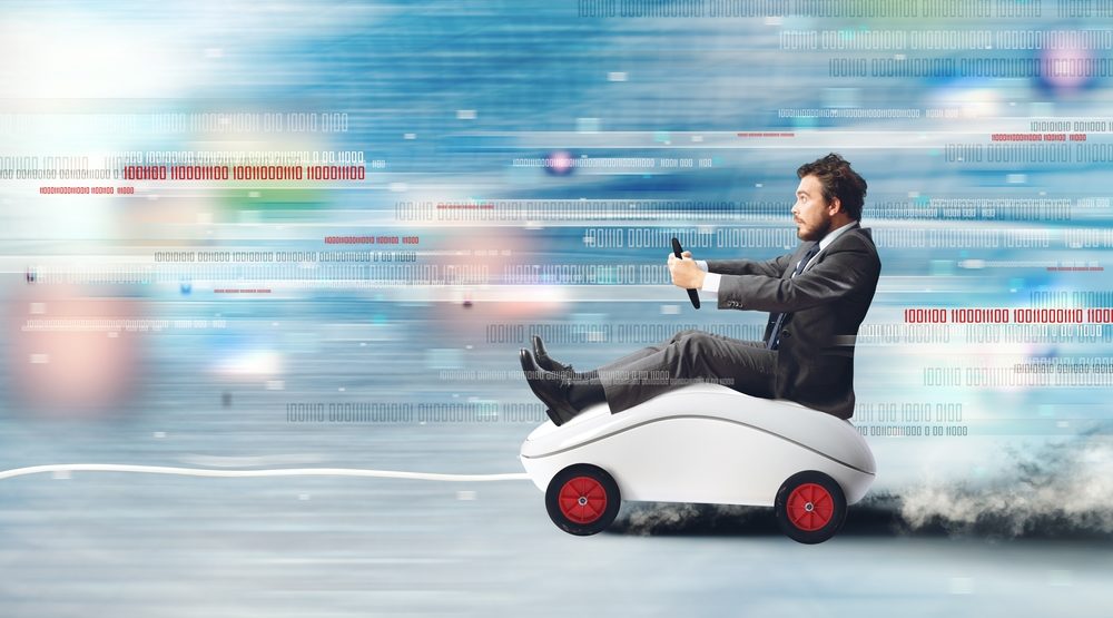 Composite image of businessman riding a speeding car, shaped like a mouse. Concept of fast internet with running mouse