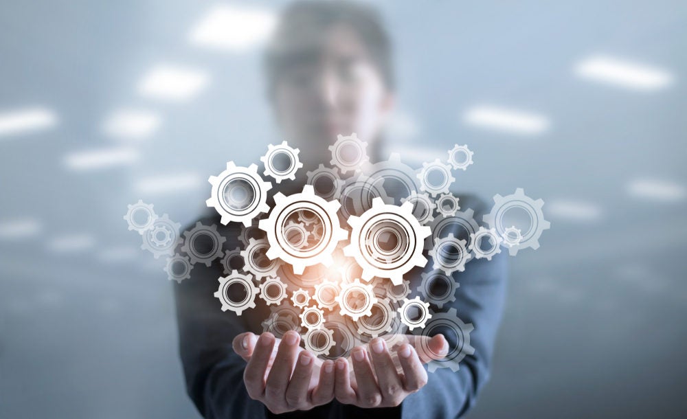 Business woman holding "cloud" image of cogs/gears, representing cloud integration.