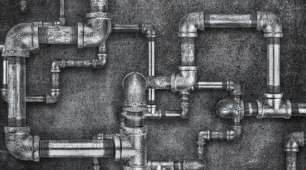 Complicated arrangement of plumbing pipes. Black and white image.