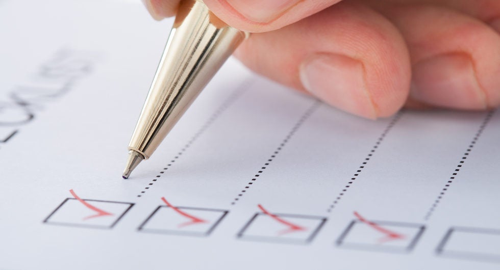 Cropped image of businessman preparing checklist at office desk