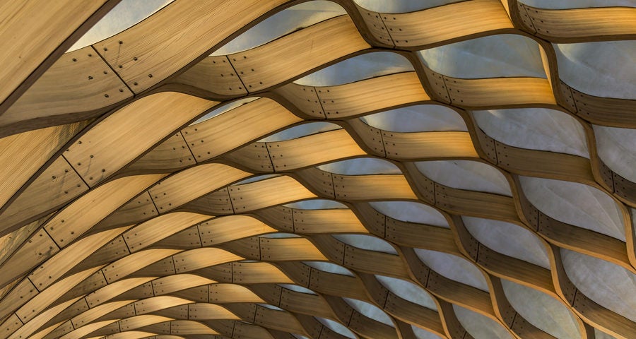 Curved wooden roof framing with translucent ceiling